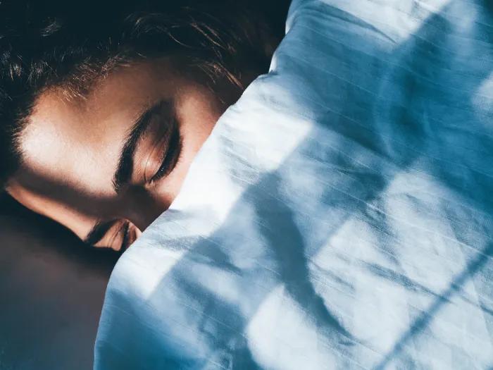 woman sleeping underneath blanket