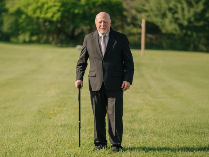 man standing with cane with suit on in black