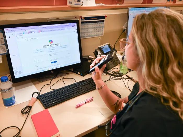 A PA talks into her phone, using DAX AI