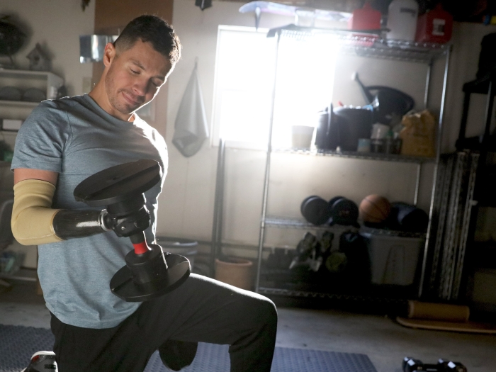 man lifting weight on knees in home gym