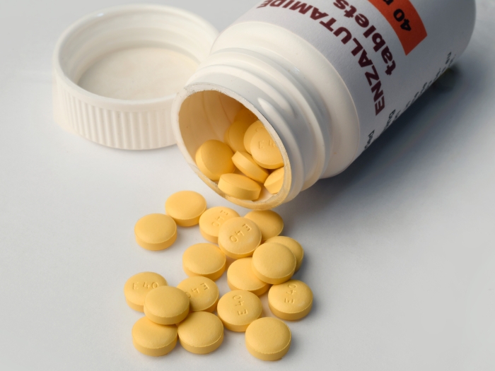 yellow pills spilling out of bottle