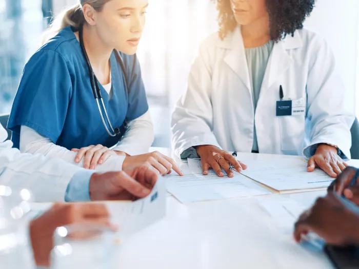 Healthcare, doctors and nurses with documents in meeting, diagnosis feedback and collaboration