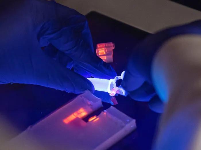 Pipette's contents being added to a microscopic slide