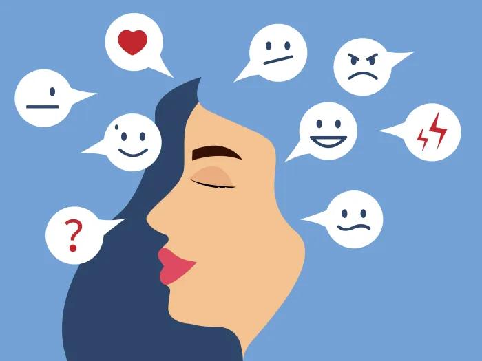 Illustration of a woman’s profile with her eyes closed, surrounded by speech bubbles displaying various emotional faces and symbols, including happiness, sadness, anger, confusion, neutrality, love, and stress, representing a range of changing emotions.
