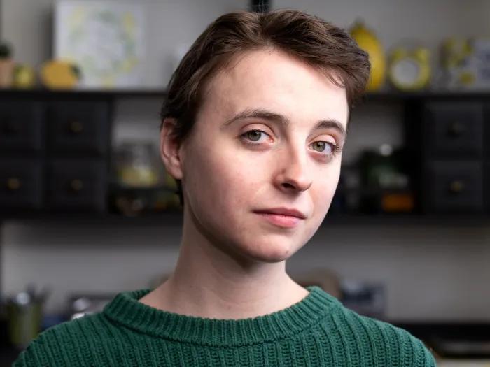 women close up of face semi-smiling in green shirt short hair brown