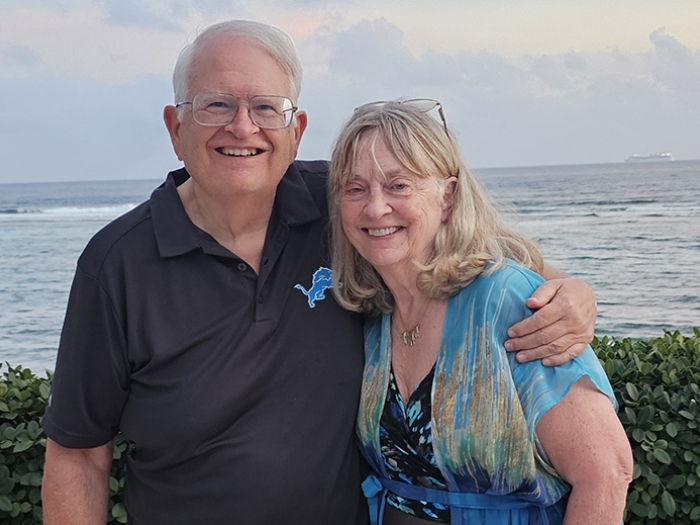 Smiling photo of the Wagners standing in front of the Caribbean in Grand Cayman.