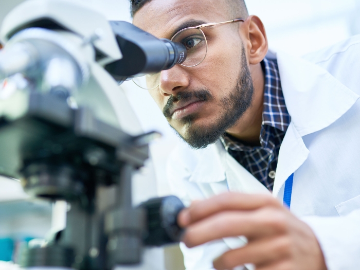 Lab member using a microscope