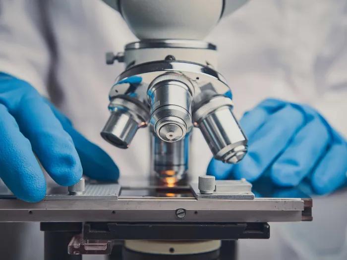 Close up of someone using a microscope