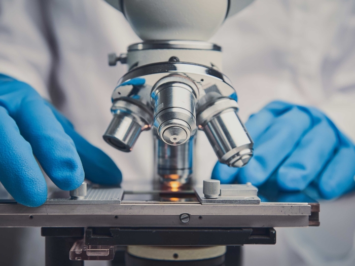 Close up of someone using a microscope