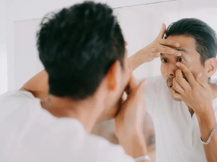 person putting contacts on up close to mirror