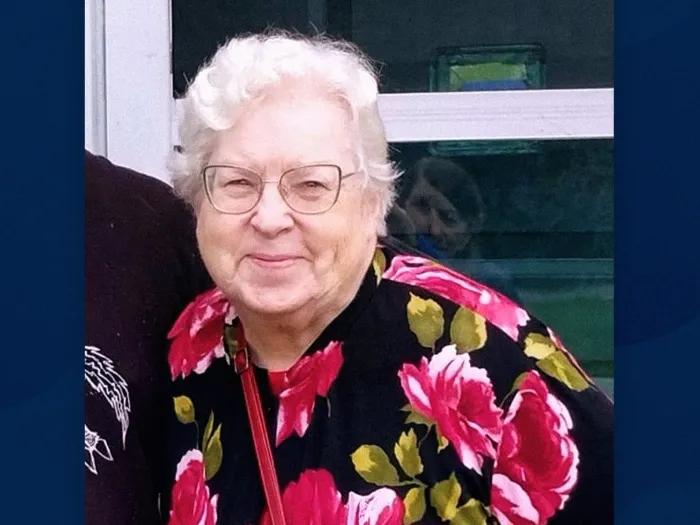 woman with glasses floral shirt smiling