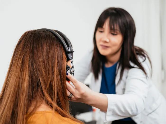 Audiologist putting headphones on a patient