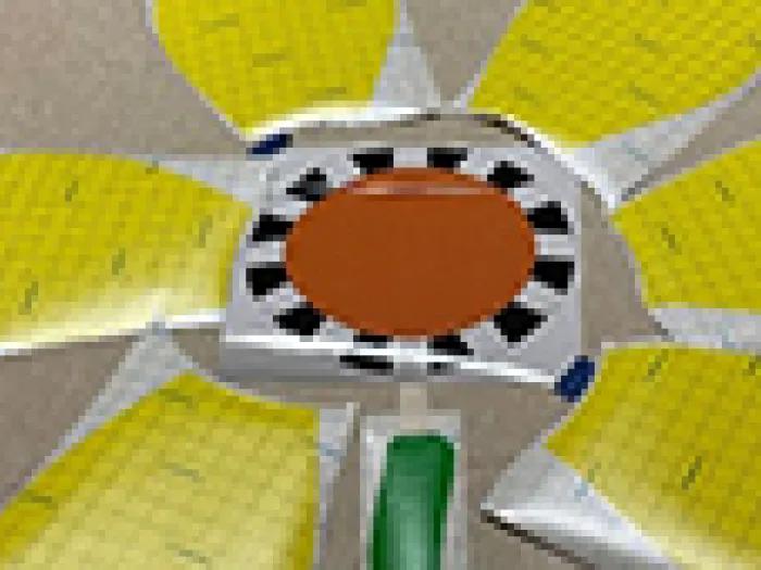 Floor decals of yellow flower petals, an orange center, and a green stem arranged like a daisy. They appear to be temporarily placed and are not yet stuck down to the floor.
