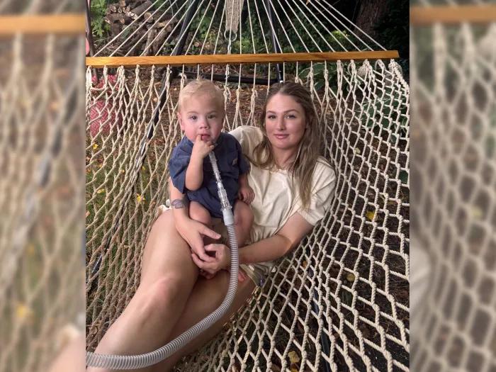 mom and son outdoors on swing together