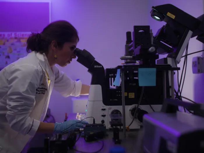 Dr. Aliabouzar leaning over a microscope