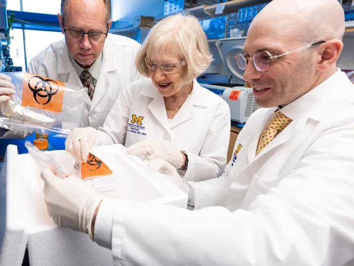 Dr. Benjamin Murdock, Eva Feldman and Stephen Goutman looking at samples in the lab