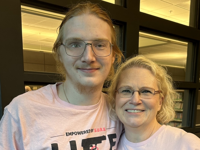 man and woman standing together in pink shirts