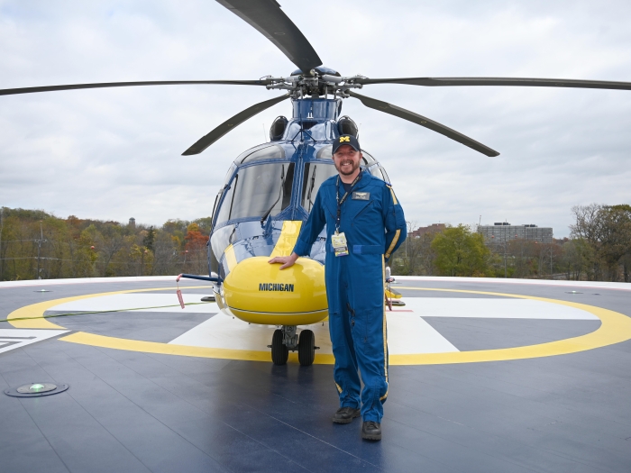Nate Hunt stands in front of a survival flight helicopter
