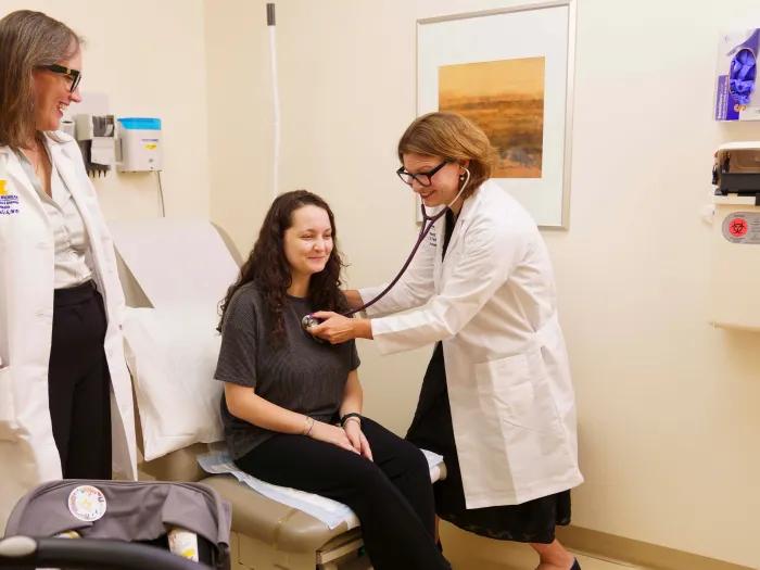 two doctors with patient listening to heart