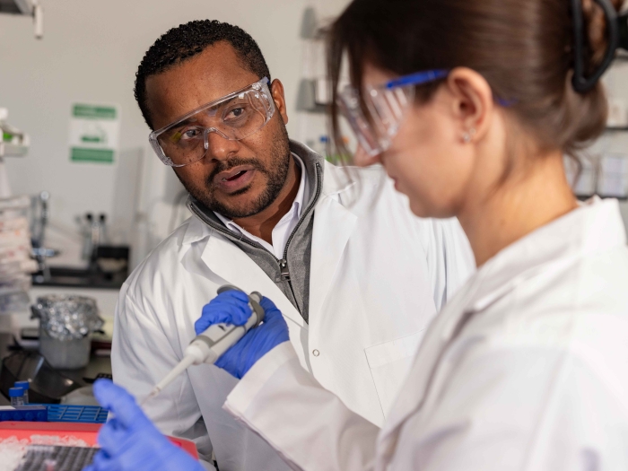 Dr. Jay Brito Querido and lab member talking and working in the lab