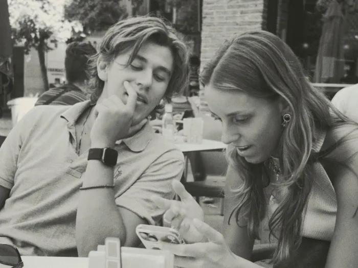 man and woman looking down at a smartphone