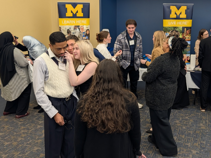 Students practice using diagnostic tools to examine ears and noses during a hands-on clinical skills session at Michigan Medicine Day at UM-Dearborn.
