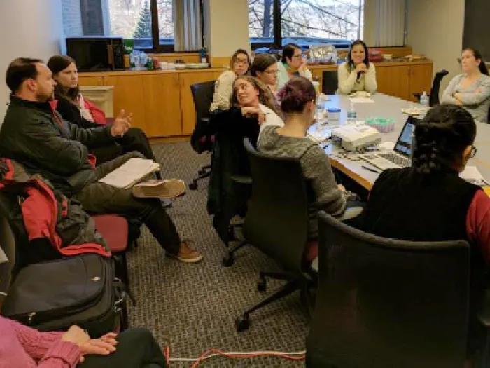 Photo of a group of people meeting in a conference room having a discussion