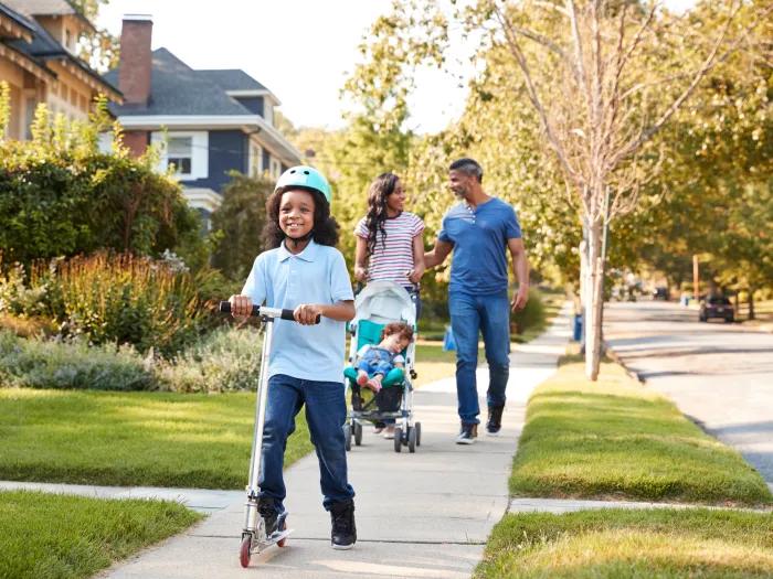 a family walking down a street in a neighborhood