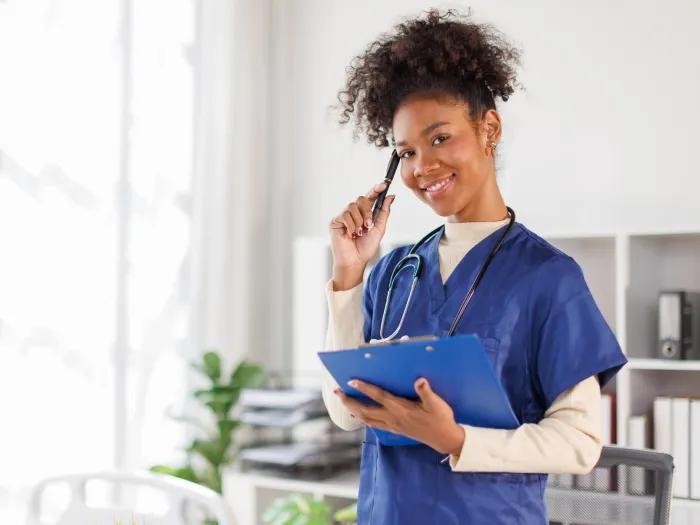 doctor posing for a phone and holding a clipboard