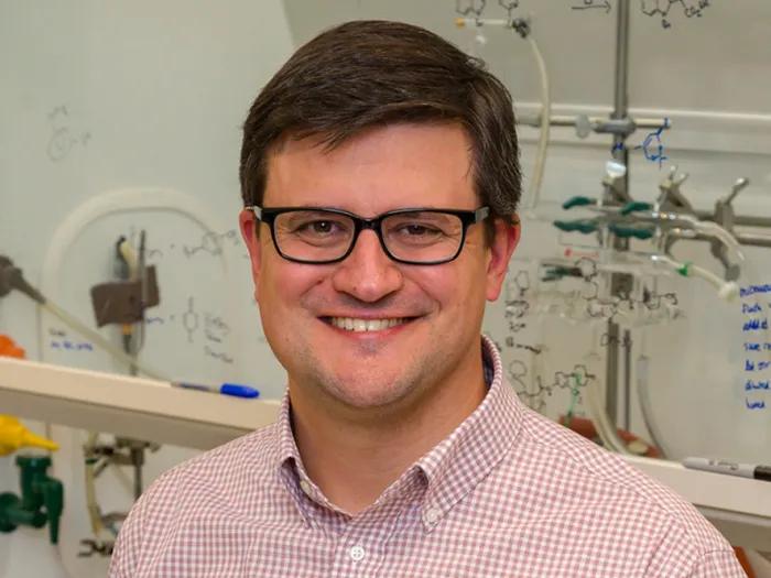 headshot of Jay Schneekloth in a chemical laboratory