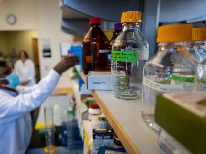 Stock image of scientist in PPE with lab equipment 