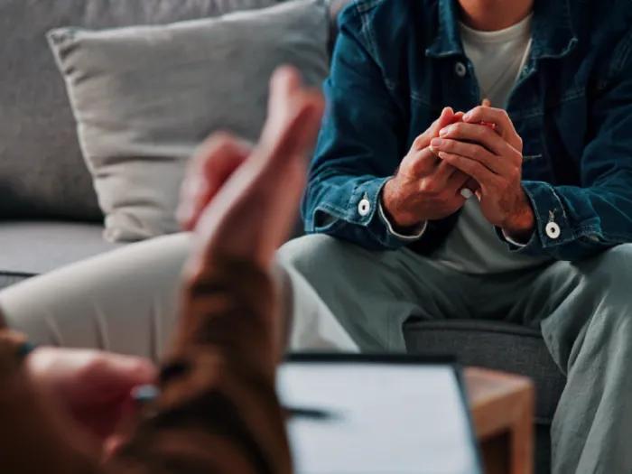 Photo of two people taking, possibly in a therapy session