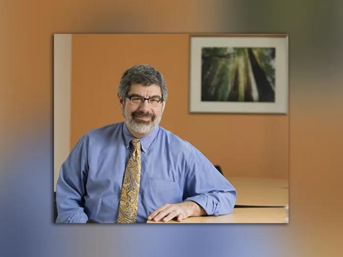 Portrait of Dr. Rosen smiling and seated at a table.