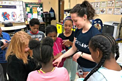med student talking to young students in a classroom 