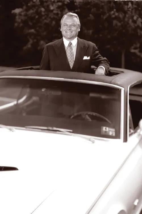 black and white photo of Heinz Prechter standing through a car's sunroof