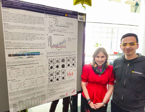 Hamadi Madhi, PhD poses with Sofia Merajver, MD, PhD next to his research poster