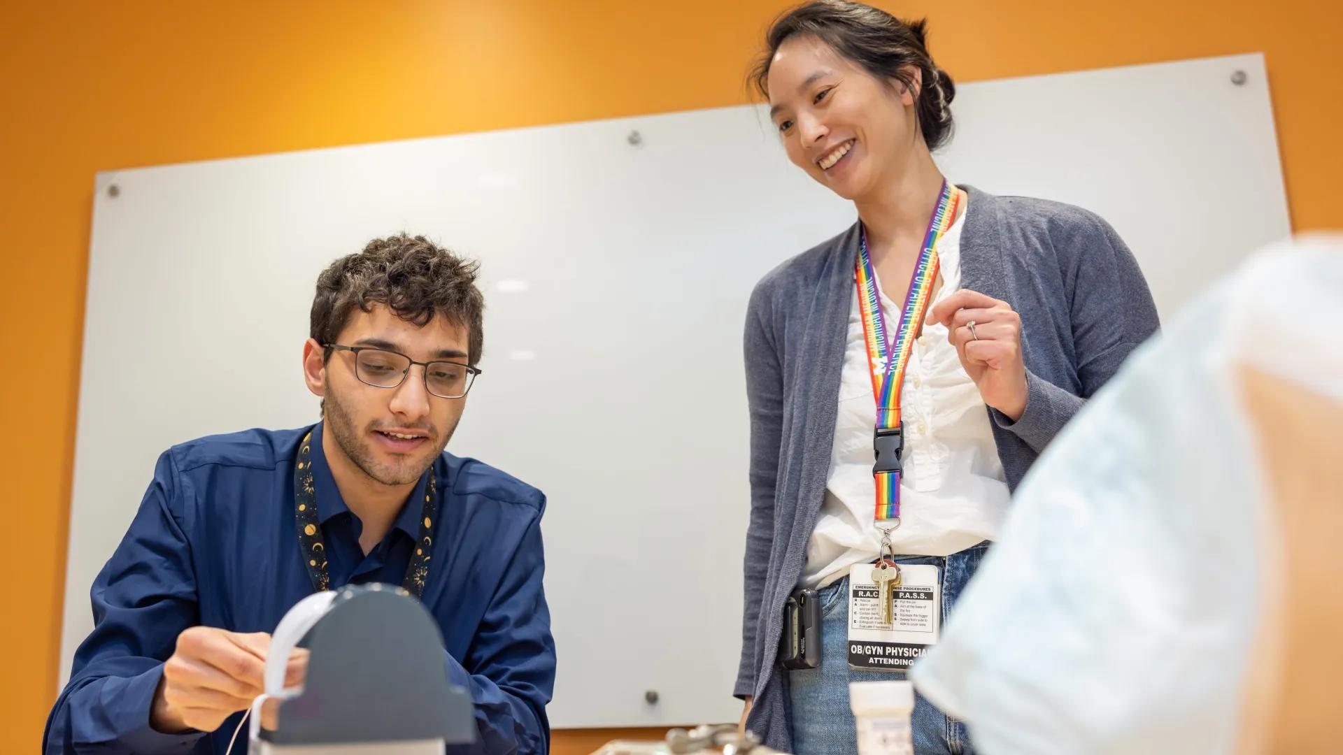  student practices his technique during a lab simulation while peer watches
