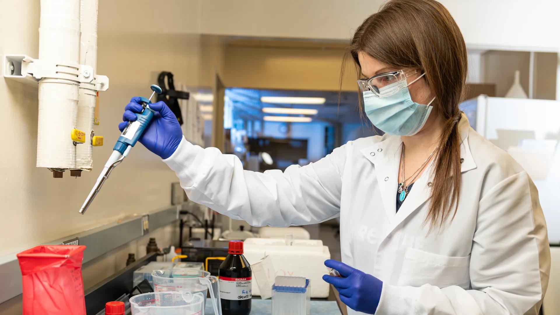 Research staff in a lab using a pipette