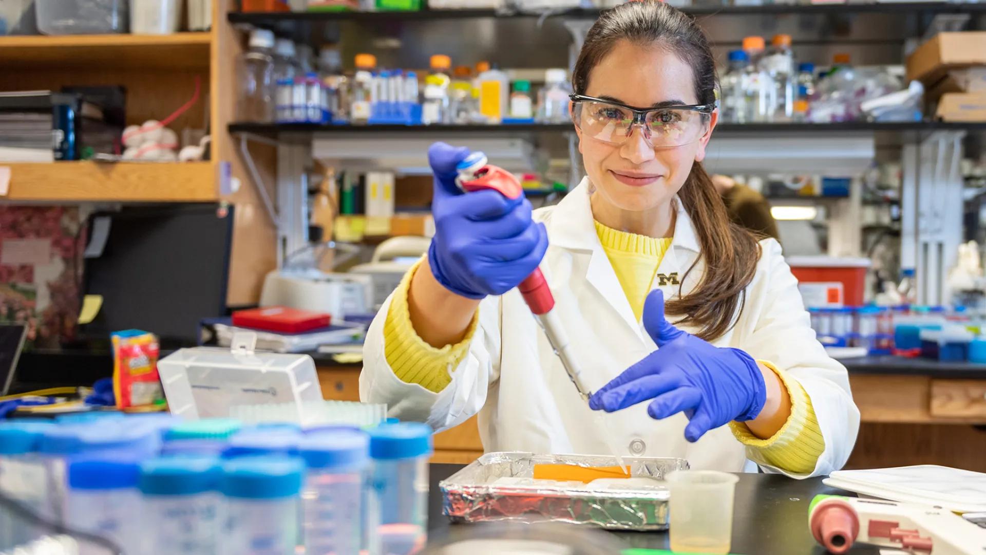 Dr. Sue Hammond in the lab working with a pipette