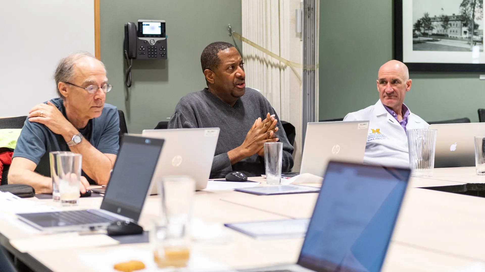 three men talking in meeting