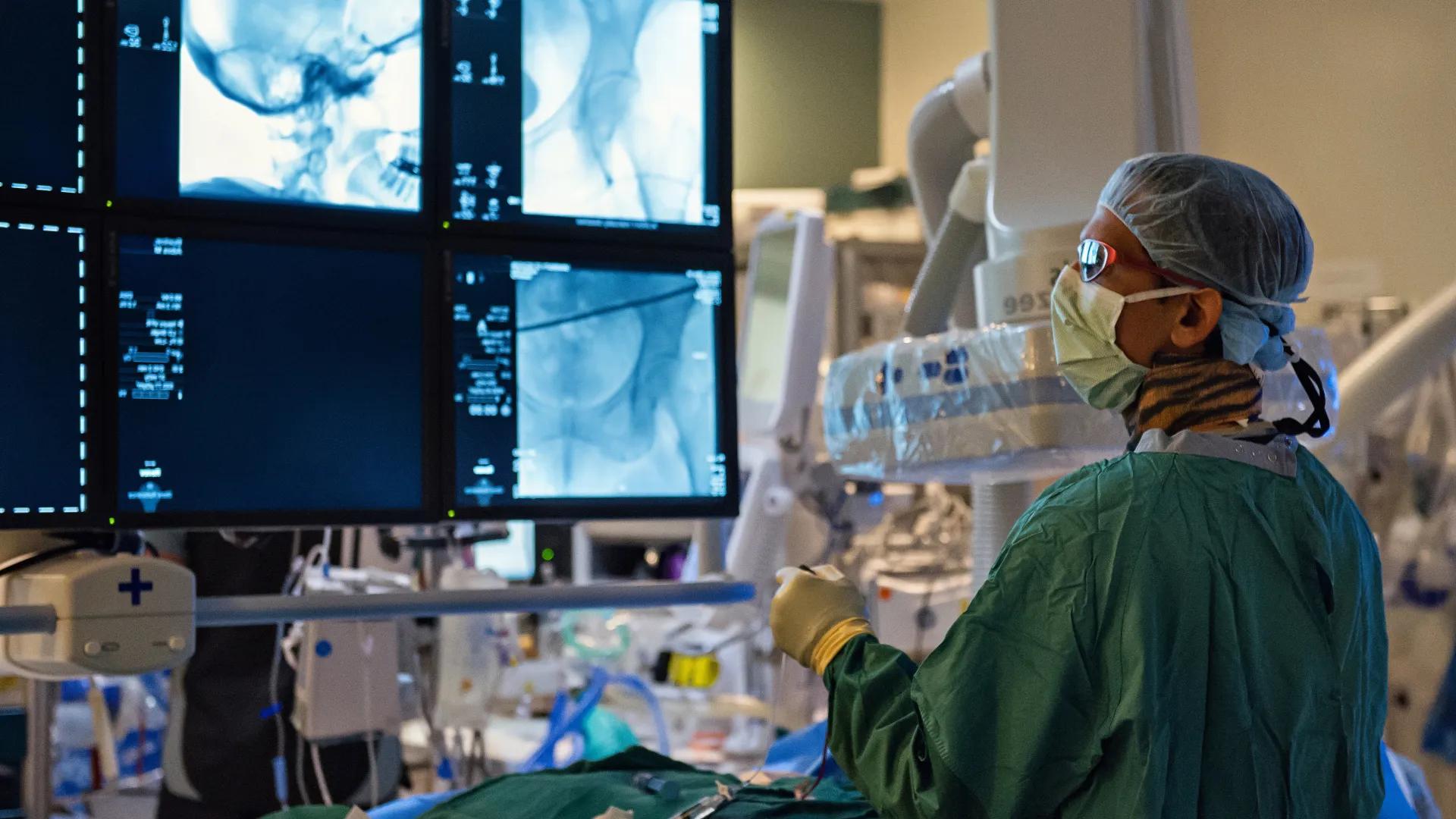 A surgeon looking at a monitor in an operating room.