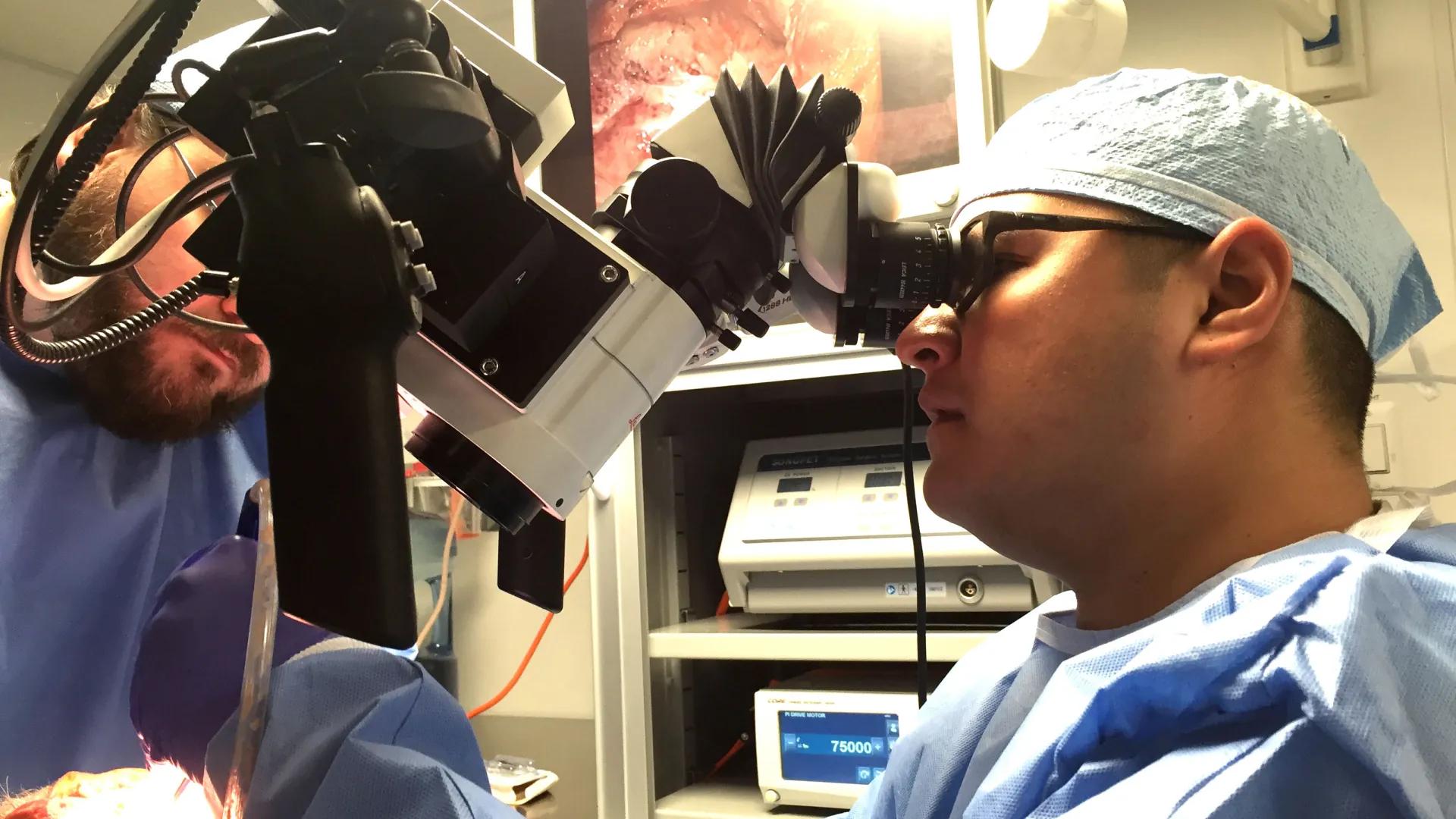a person looking through a microscope