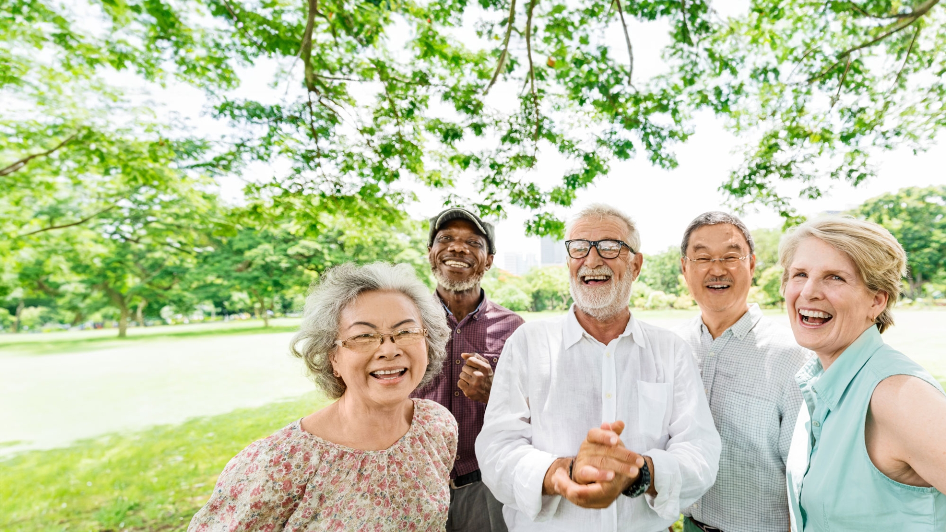 Three older gentlemen and two older ladies smiling in a group outside