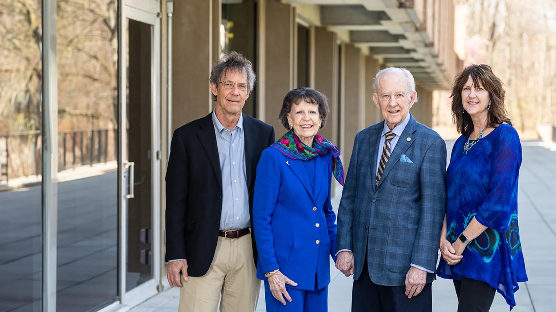 Group of four people posing for a photo outside