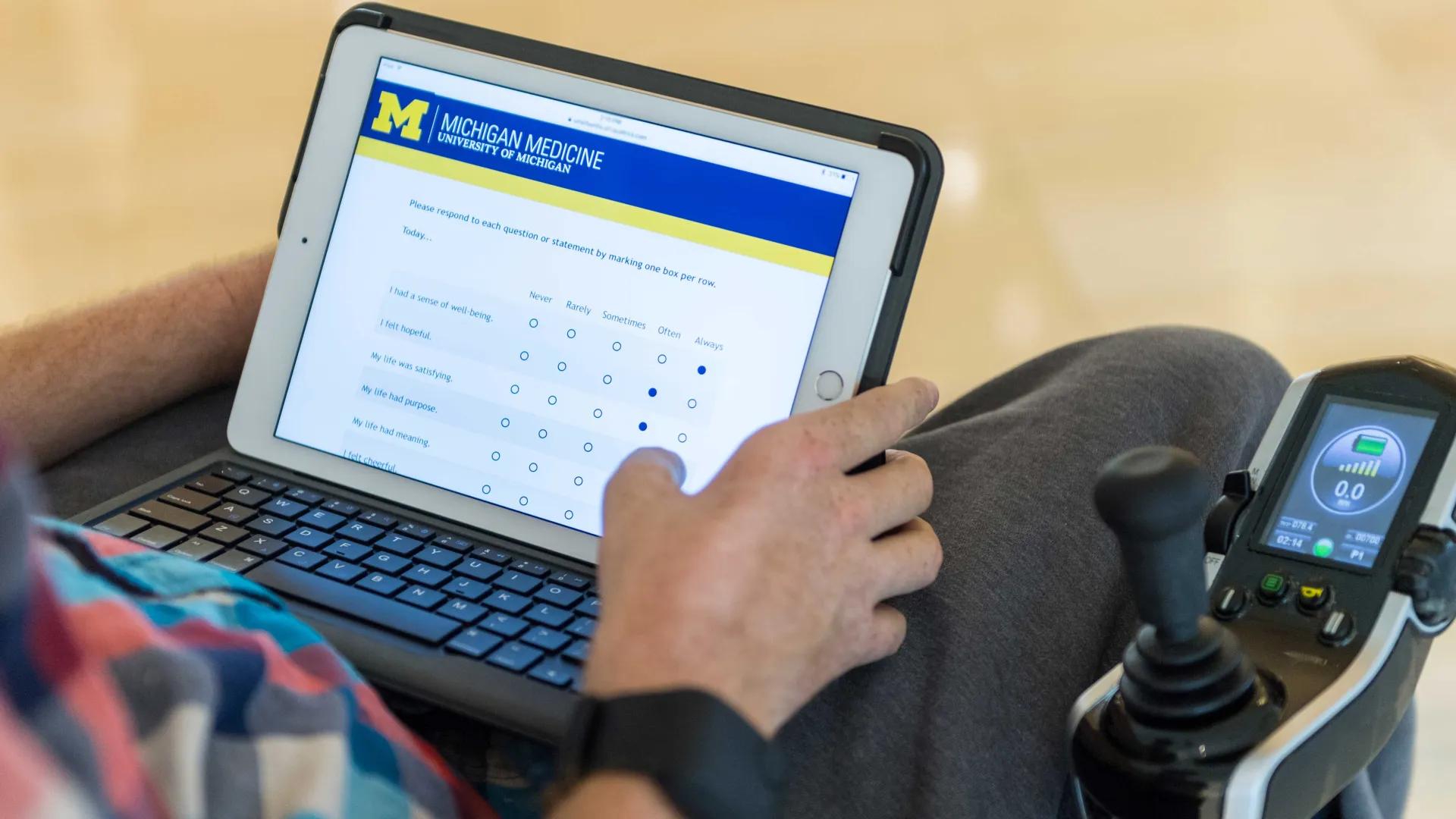 Close up of someone in a wheelchair filling out a survey with questions related to wellness