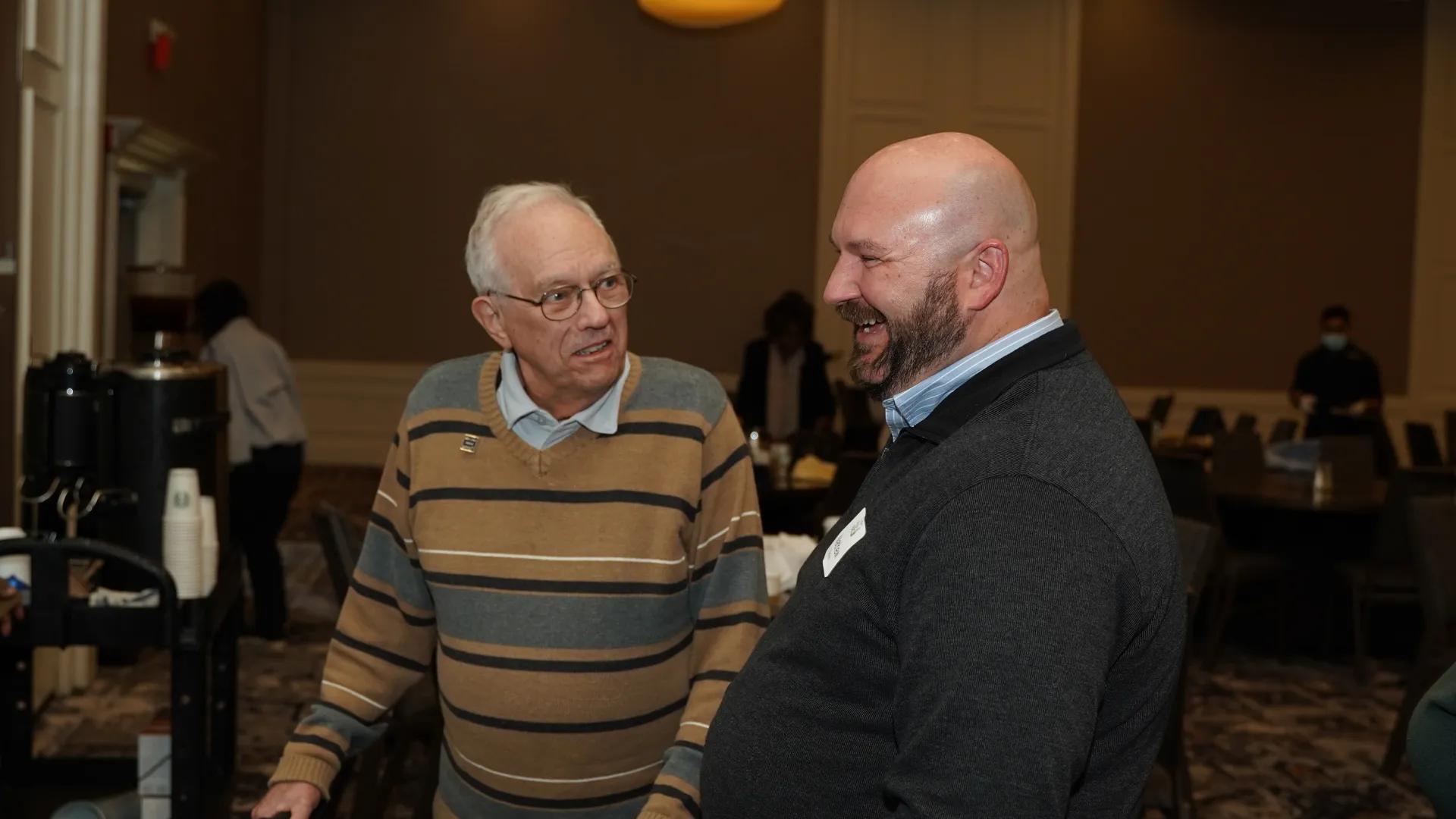 an older gentleman with a bald man talking