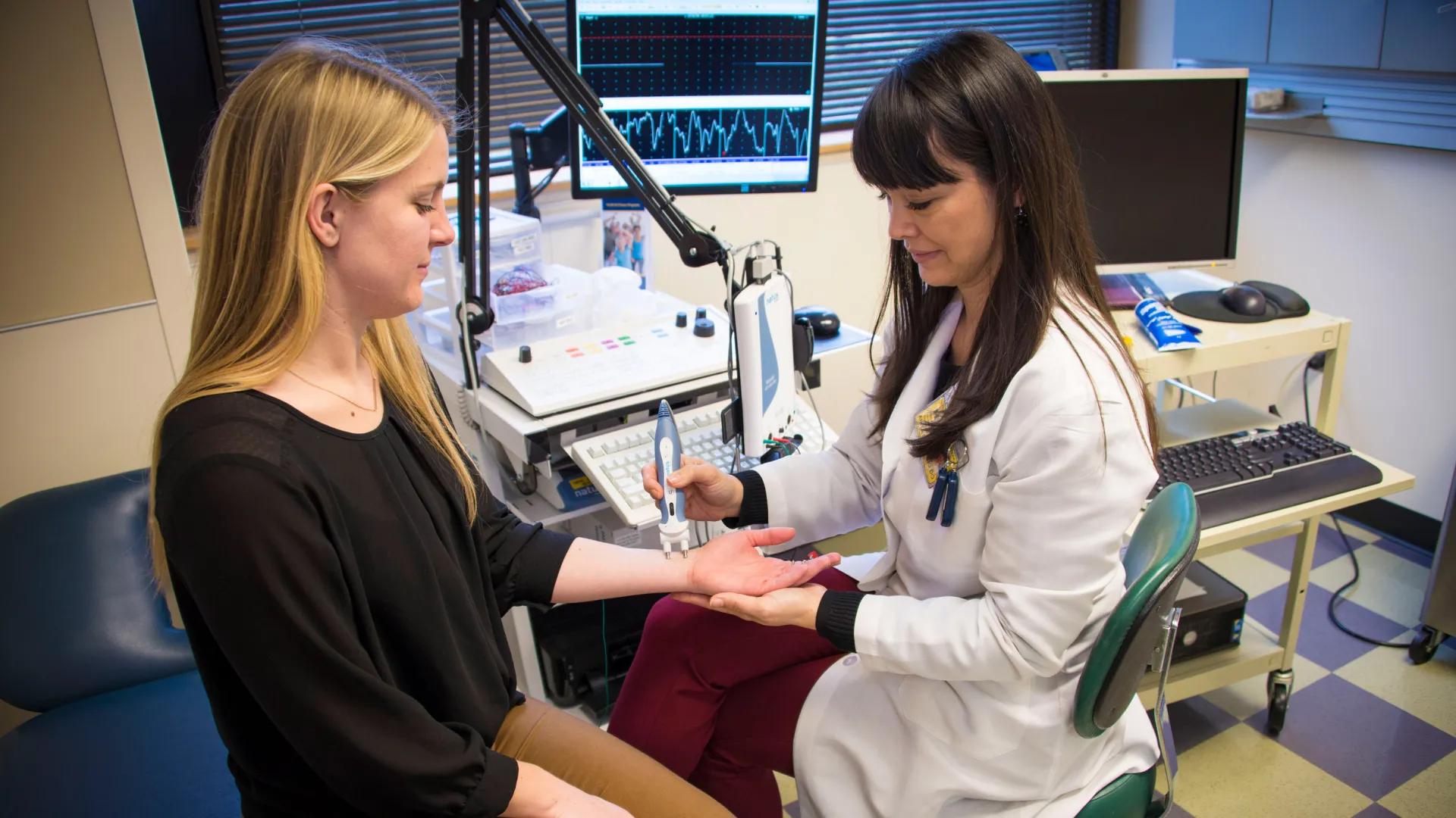 Doctor using medical device on patient's left wrist