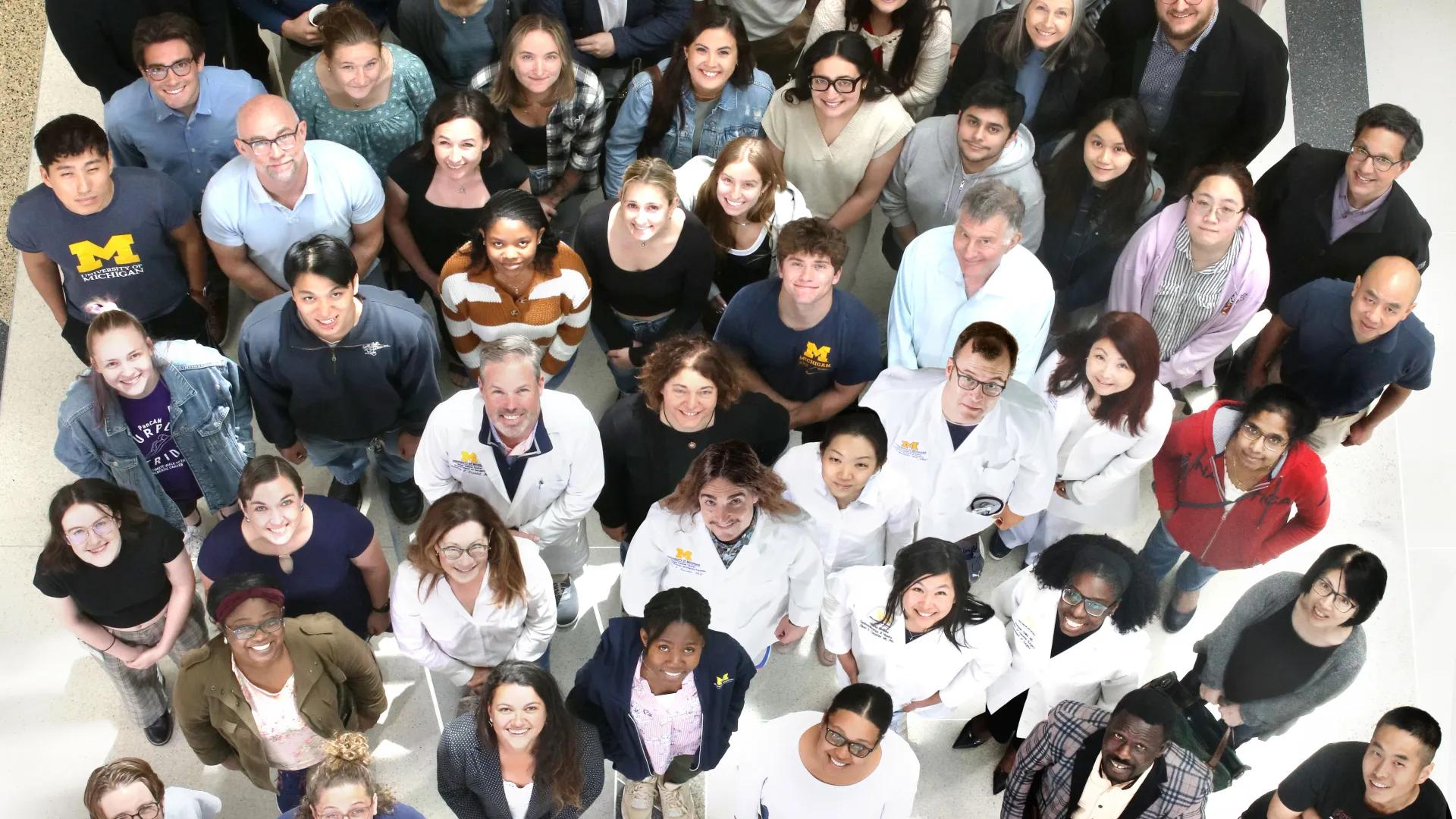 Overhead view of Rogel and Blondy team looking up at the camera