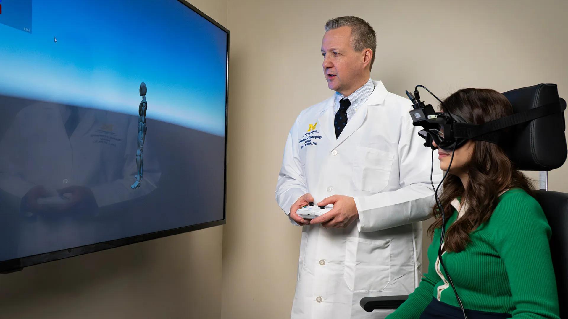 Dr. McCaslin looking at a screen and talking with someone using virtual reality headset