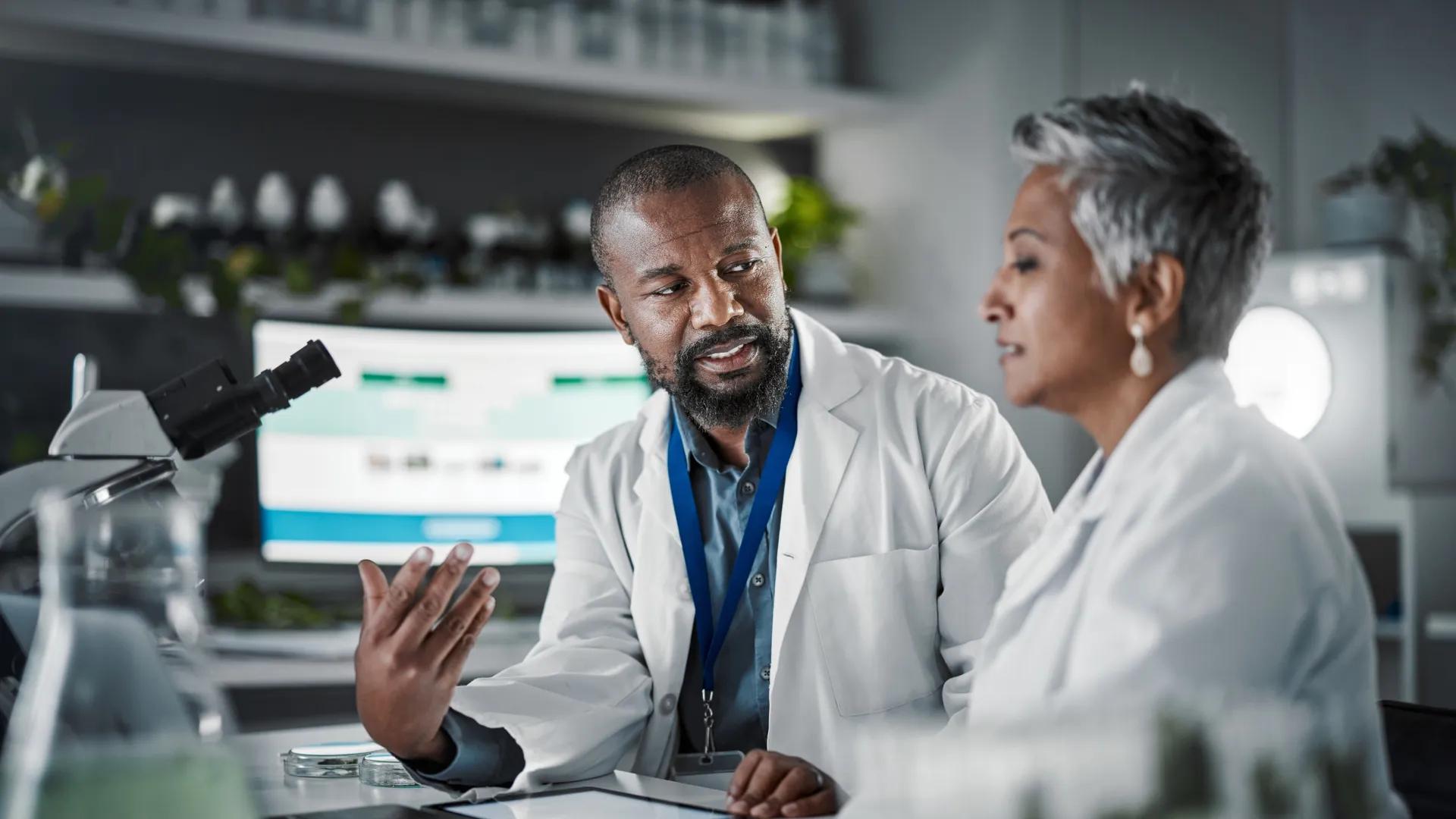 Two people in a lab speaking together